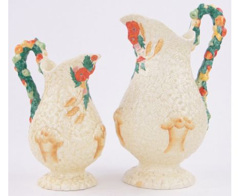 A graduated pair of Clarice Cliff Barbola pattern jugs,with fruit embossed handles, largest height 28cm.