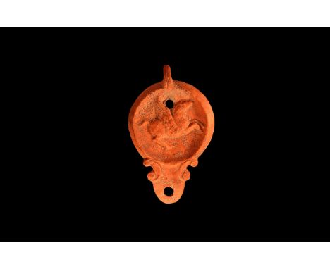 An undated archaistic ceramic redware oil lamp in 1st-2nd century AD style, with rounded nozzle and small pelta shaped volute