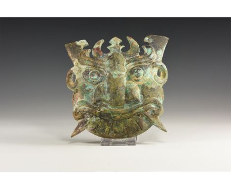 An undated archaistic Western Zhou Period style mask with large almond shaped eyes, curving eyebrows and large flat nose with