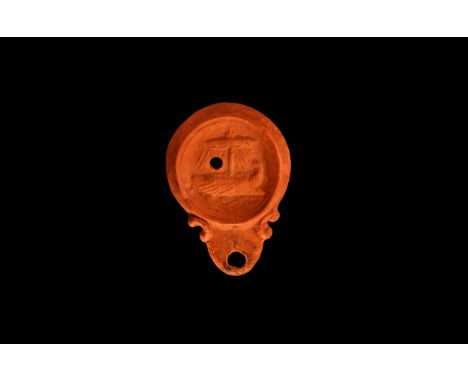 An undated archaistic ceramic redware oil lamp in 1st-2nd century AD style, with rounded nozzle and small pelta shaped volute