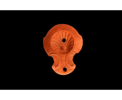 An undated archaistic ceramic redware oil lamp in 1st-2nd century AD style, with rounded nozzle, pelta shaped volutes to the 