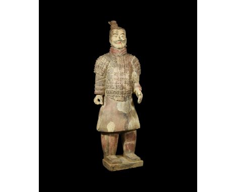 A very large undated archaistic hollow-formed ceramic figurine of a standing warrior with hands raised, dressed in a loose fl