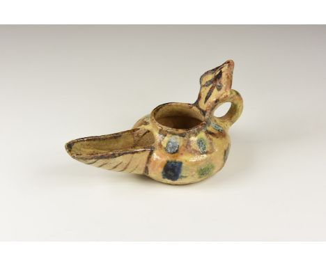 An undated archaistic glazed ceramic oil lamp with squat body, scooped spout, lozengiform reflector panel, loop handle to the