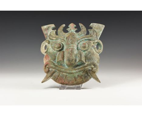 An undated archaistic Western Zhou Period style mask with large almond shaped eyes, curving eyebrows and large flat nose with