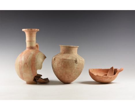 2nd millennium BC. A group of three fragmentary ceramic vessels comprising: a hemispherical bowl with single loop handle, ver