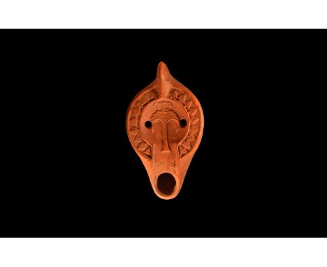 An undated archaistic redware ceramic oil lamp in 7th-8th century AD style with lug handle, thick squat body and short nozzle