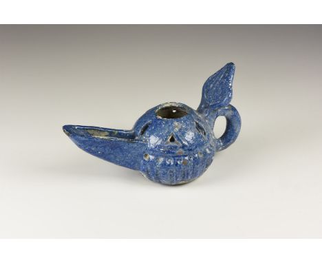 An undated archaistic glazed ceramic oil lamp with domed body, long scooped spout, vents to the shoulder, piriform reflector 