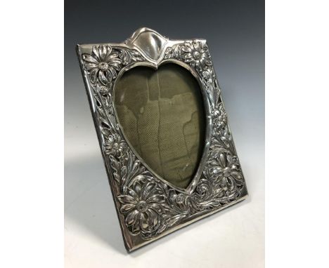 by Henry Matthews, Brimingham 1902, of rectangular portrait form, with heart shaped aperture, the border of embossed dasies a