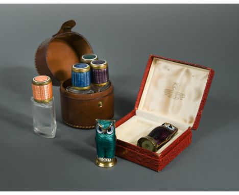 one in green enamel the other in amethyst, together with a leather cased set of four enamel topped glass scent bottles