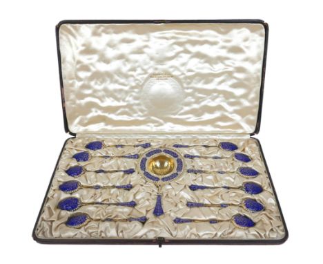 David Andersen for Tiffany &amp; Co, a thirteen piece silver gilt and enamel tea spoon and strainer set, decorated with scrol