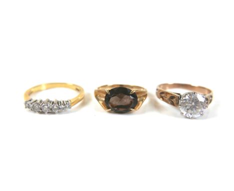 A group of three gold rings, comprising a diamond seven stone ring, size N, a smokey quartz set vintage dress ring, size H, a