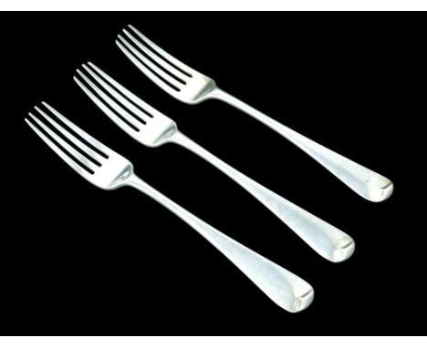 Three Georgian silver rat tail table forks, armorial crests to back of finials, rubbed hallmarks, 21cm long, 5.9toz overall. 
