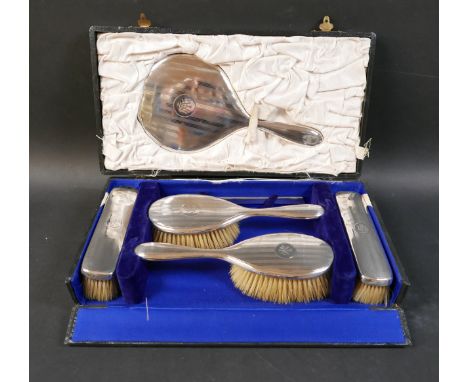 An Edwardian silver backed dressing table hair brush set, with hand mirror, 27cm, two hair brushes with handles, 24cm, two bl