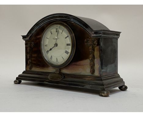 An early 20th century silver plated dome top mantel clock, the case with trailing bow ribbon hare bell appliques and presenta