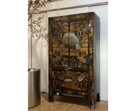 A late 19th century Chinese marriage cabinet, the lacquered exterior with typical chinoiserie embossed gilt decoration depict