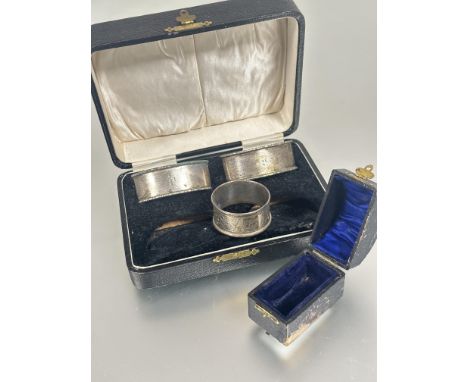 A boxed set of two Edwardian Birmingham silver navette shaped engine turned napkin rings L x 6.5cm and a Chester circular cha