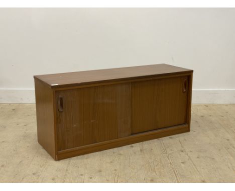 A mid century teak veneered side cabinet, fitted with two sliding doors enclosing a shelf. H48cm, W108cm, D37cm.