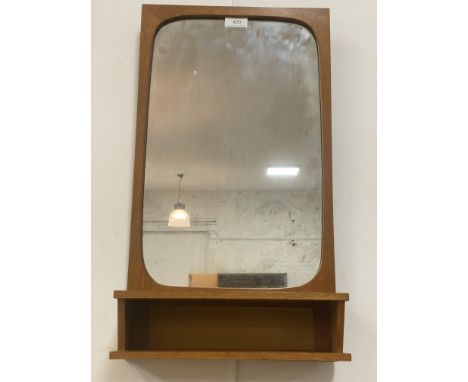 A mid century Danish wall hanging mirror with integrated open shelf, Danish control label verso. H59cm.