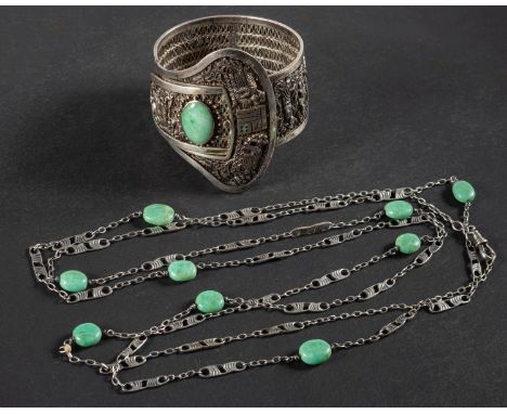A Chinese filigree-work, buckle-shaped, hinged bangle, set with a cabochon-cut jadeite, depicting scenes garden scenes, inner