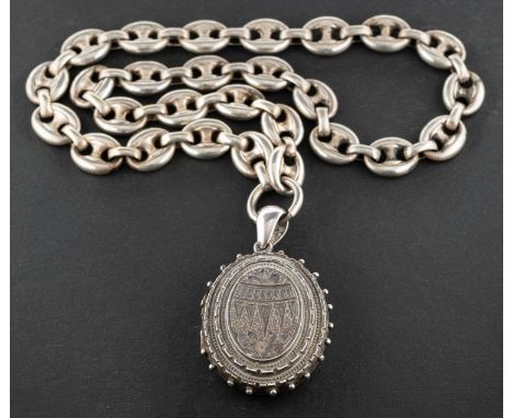 A Victorian, Etruscan revival, silver, oval locket pendant, with floral engraving and hallmarks for Birmingham, 1881, togethe