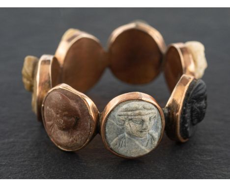 A Georgian, carved lavastone cameo ring, with the carved cameo heads depicting the days of the week, probably a souvenir from