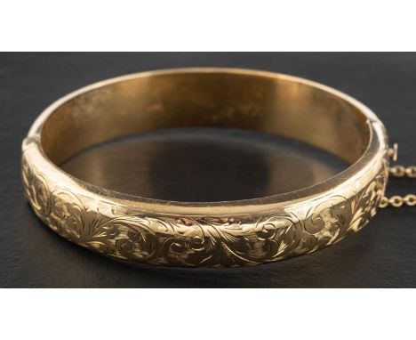 A 9ct gold hinged bangle with foliate engraving, with hallmarks for Chester, 1956, inner diameter ca. 6cm, total weight ca. 1