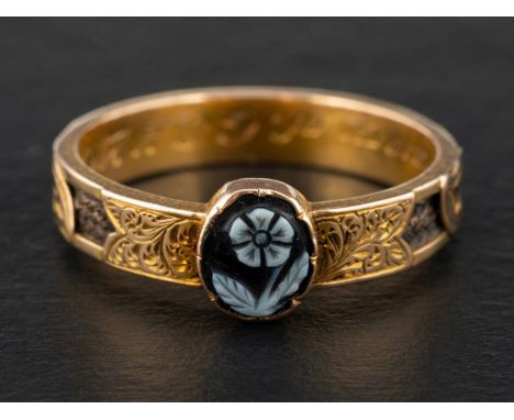 A late Victorian, gold, mourning ring, set with a carved sardonyx depicting a forget-me-knot, symbolising true love and remem
