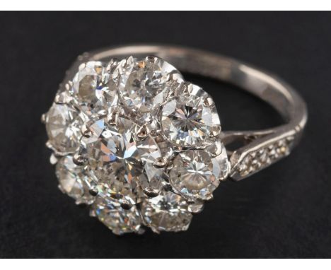 A round, brilliant-cut diamond cluster ring, estimated weight of principal diamond ca. 1.30cts, H-I colour, SI1-2 clarity, to