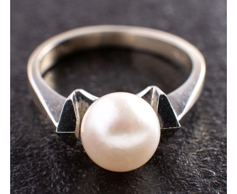 A cultured pearl dress ring, the cultured pearl of white hue with pinkish overtones, diameter ca. 7.8mms, stamped '750', leng