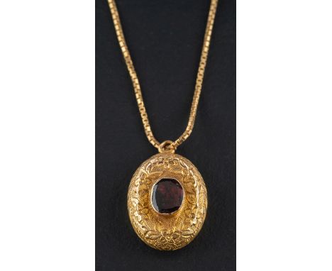 A late Victorian/ Edwardian, foiled back garnet, oval locket pendant, with engraved floral decoration, together with a 9ct go