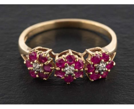 A 9ct gold ruby and diamond triple flowerhead ring, estimated total ruby weight ca. 0.35cts, with hallmarks for London, 2004,