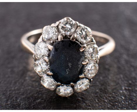 An 18ct gold, mixed-cut oval sapphire and round, brilliant-cut diamond cluster ring, estimated sapphire weight ca. total esti