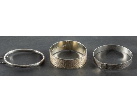Three bangles, including a hinged bangle with engraved decoration, with hallmarks for Chester, 1960, inner diameter ca. 6.5cm