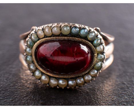 A Georgian mourning ring, the foiled back garnet with seed pearl surround, inscription to verso ''Wm Durham ob: 14 Febr 1803 