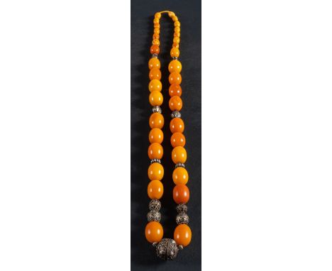 A graduated amber bead necklace, with ropework and foliate decorated spacers, the amber of varying hues from light yellow to 