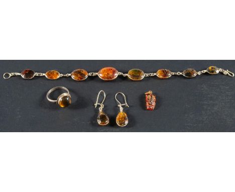 A pressed amber, spectacle set bracelet and pair of earrings, accompanied by an amber ring and carved owl charm, the earrings