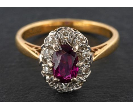An oval, mixed-cut ruby and single-cut diamond cluster ring, estimated ruby weight ca. 0.50ct, stamped '18CT', length of ring