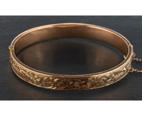An early 20th century 9ct gold, hinged bangle, with engraved foliate and floral decoration, with hallmarks for Chester, 1912,
