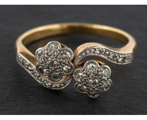 A single-cut diamond, double-flowerhead ring, of cross-over design, total estimated diamond weight ca. 0.20ct, stamped '18CT'