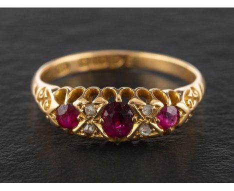 An Edwardian, 18ct gold, mixed-cut ruby three-stone ring, with rose-cut diamond spacers, 0.35cts, with hallmarks for Chester,