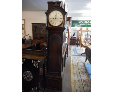 An 18th Century longcase clock with silvered circular dial, in an oak case with shaped hood, cut brass spandrels, arched door