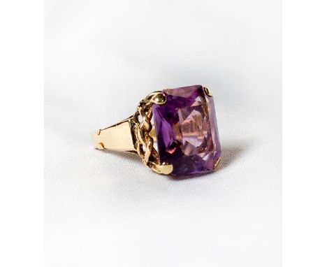 A lady's dress ring set amethyst, on a gold coloured metal shank