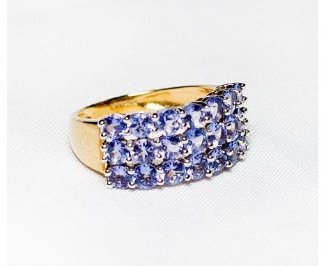 A lady's dress ring set three rows of seven lilac coloured stones, on a 9ct. gold shank