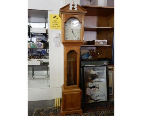 A longcase clock with enamel dial decorated birds, in a pine case with arched pediment, turned finial, glass door and panelle