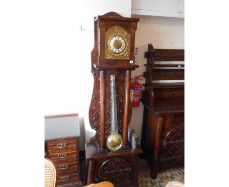 A Continental longcase clock with brass dial, white enamel numeral pads, in a stained pine case with stud decoration, turned 