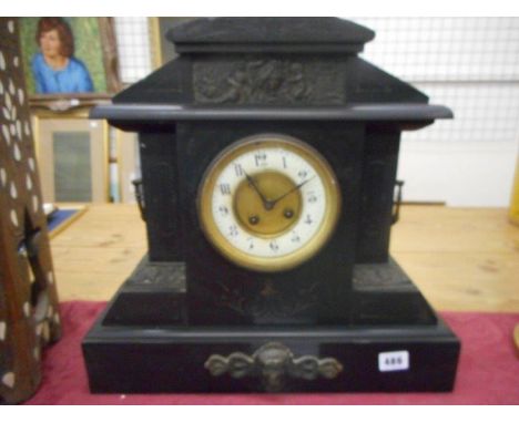 A Victorian mantel clock with cream enamel chapter ring, in a black slate case with incised decoration, fitted twin handles a
