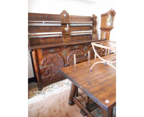 A French stained pine dining table with rectangular top, on turned legs, a set of four dining chairs with ladder backs, a ben