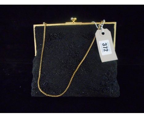 A vintage Gucci black beaded evening bag with pink silk interior and mirror