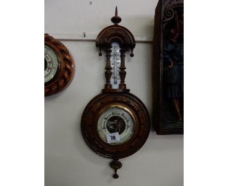 A Victorian barometer and thermometer on a carved walnut mount with pointed finials