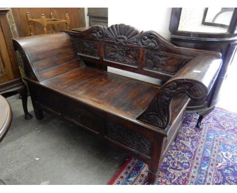 A Chinese softwood sofa with carved back to flower design, scroll arms, hard seat, the base fitted centre drawer flanked by c